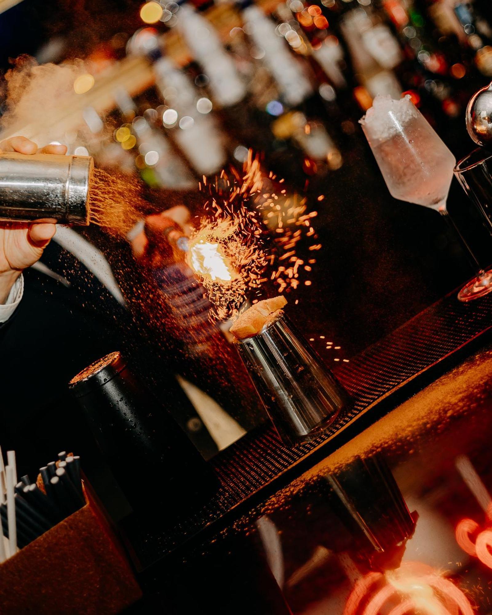 138 Liberdade Hotel Lissabon Buitenkant foto A bartender using a cocktail gun to make a flaming shot